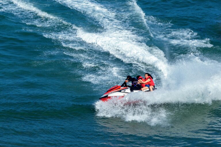 Group enjoying a thrilling jet ski ride on the ocean, creating splashes and waves.